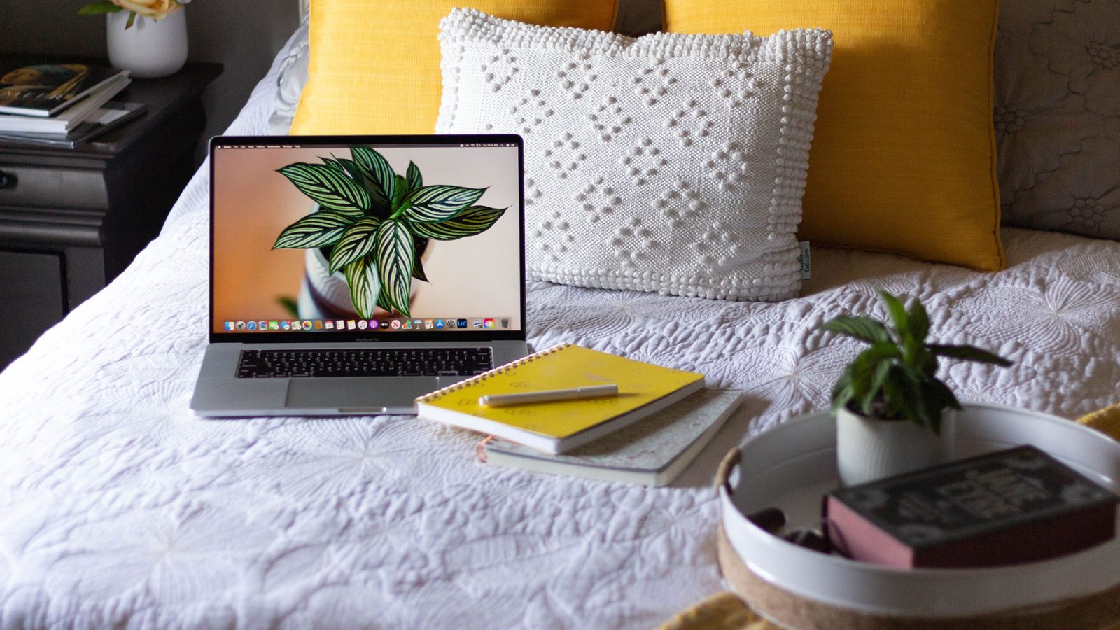 Stock photo of a laptop and journal on a bed