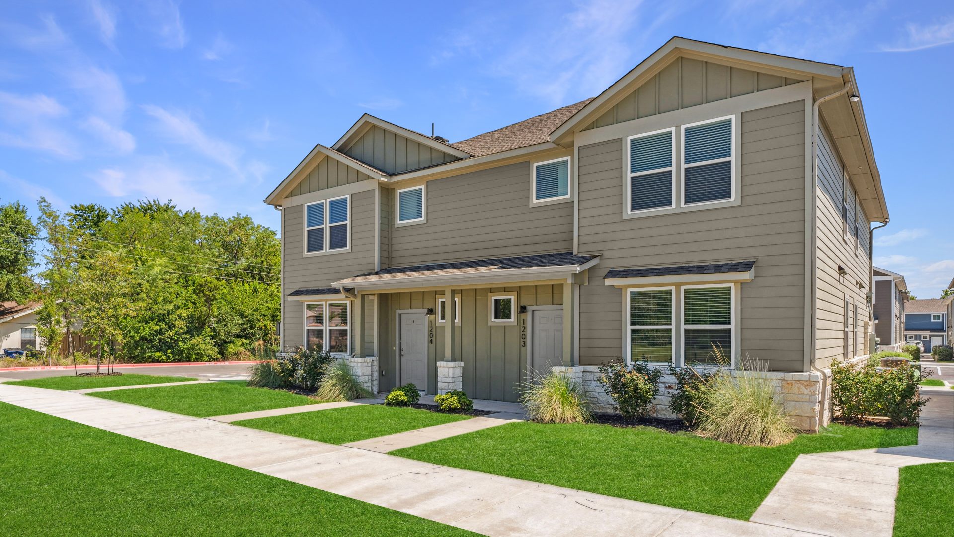 a two story home with grass and a driveway at The  Powell