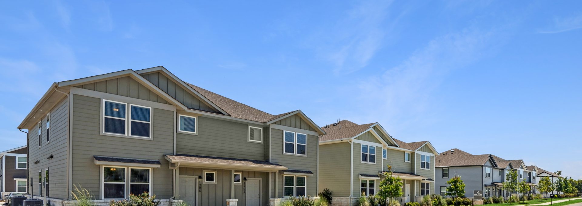 a row of townhouses with green grass and trees at The  Powell