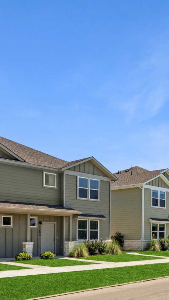 a row of townhouses with green grass and trees at The  Powell