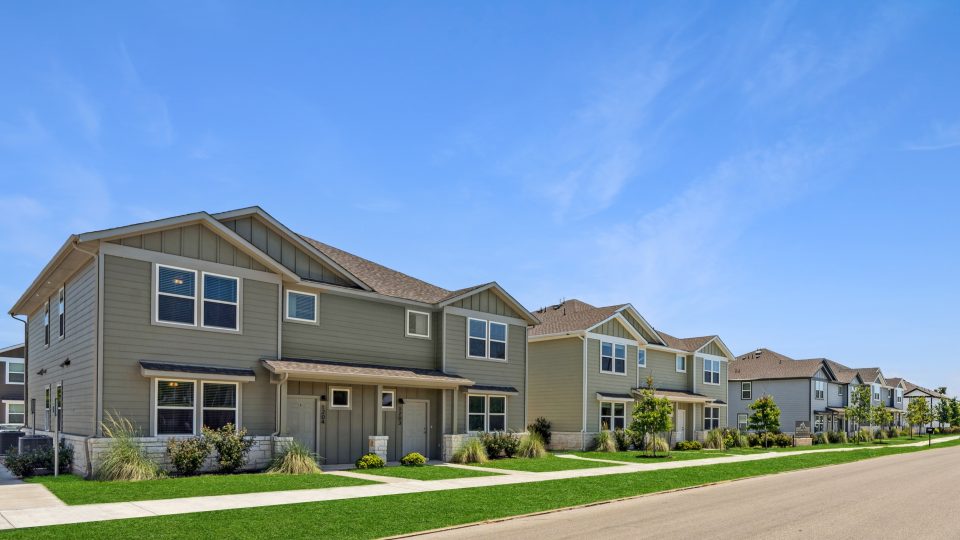 a row of townhouses with green grass and trees at The  Powell