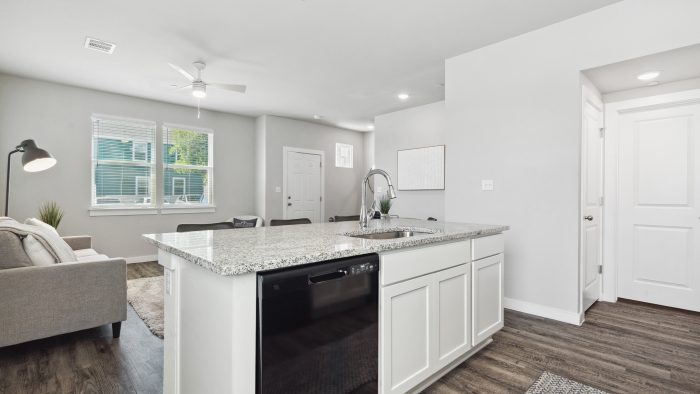 a kitchen with white cabinets and hardwood floors at The  Powell