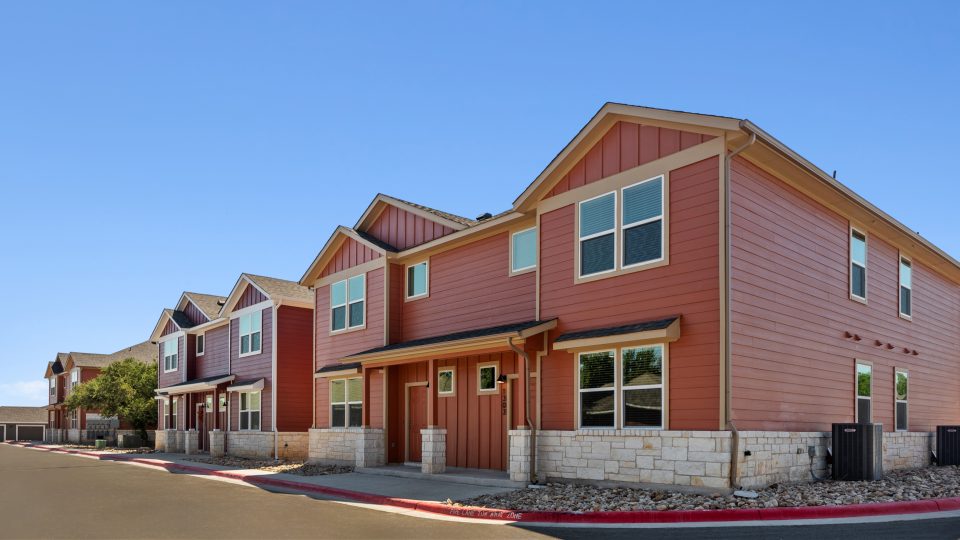 a row of townhomes with red and brown siding at The  Powell