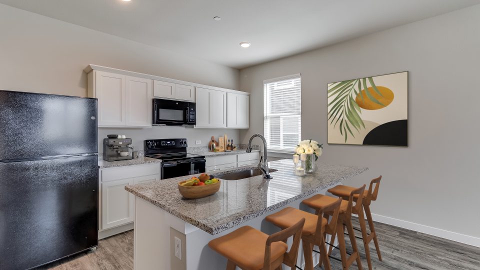 Townhome kitchen with an island and black appliances at The Powell