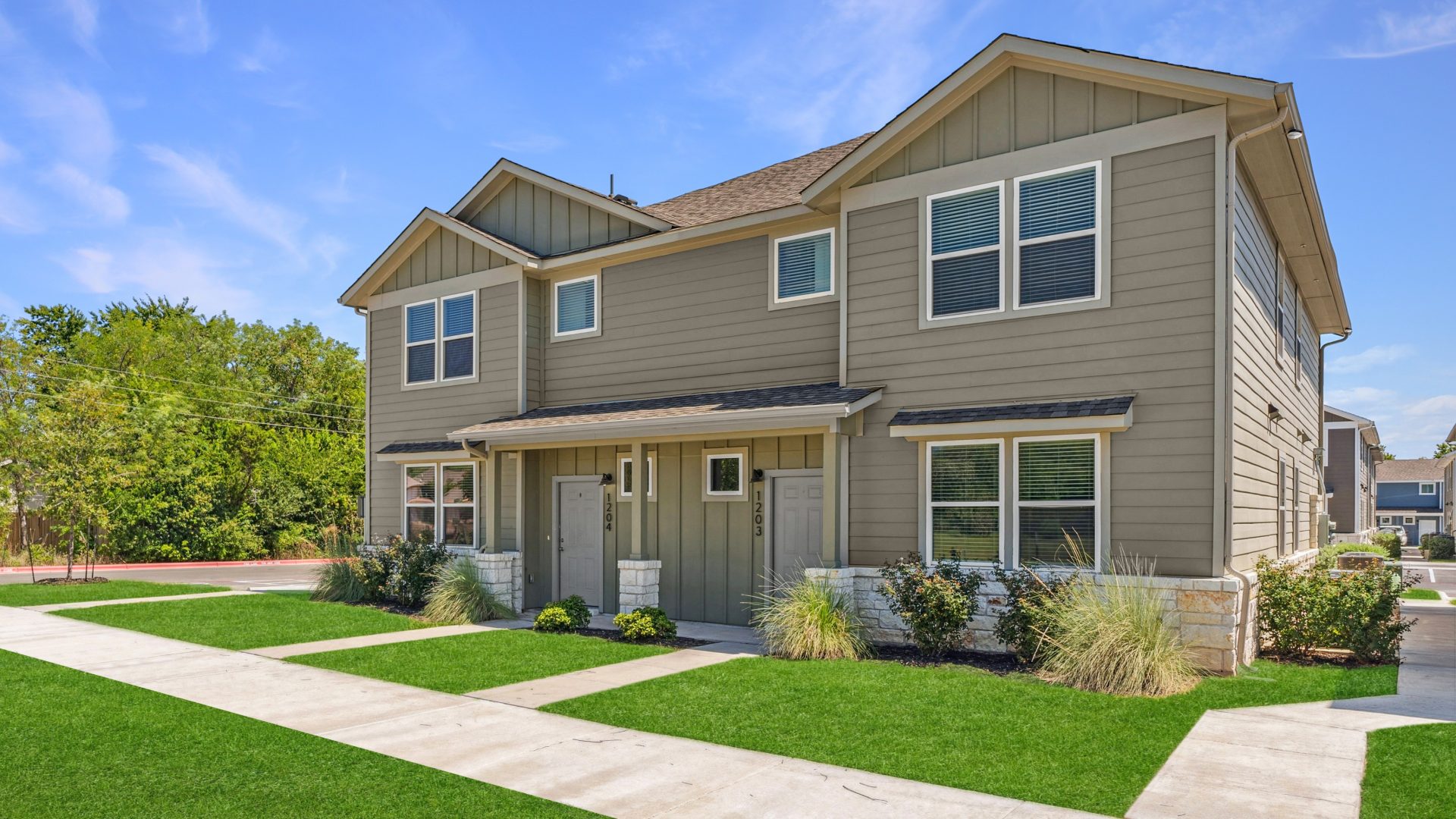 a two story home with grass and a front yard at The  Powell